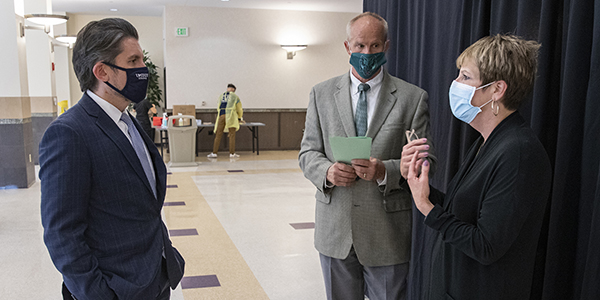 SUNY Chancellor James Malatras, left, speaks with Binghamton University President Harvey Stenger and Johann Fiore-Conte, associate vice president for student affairs, at the University's COVID-19 surveillance testing center.