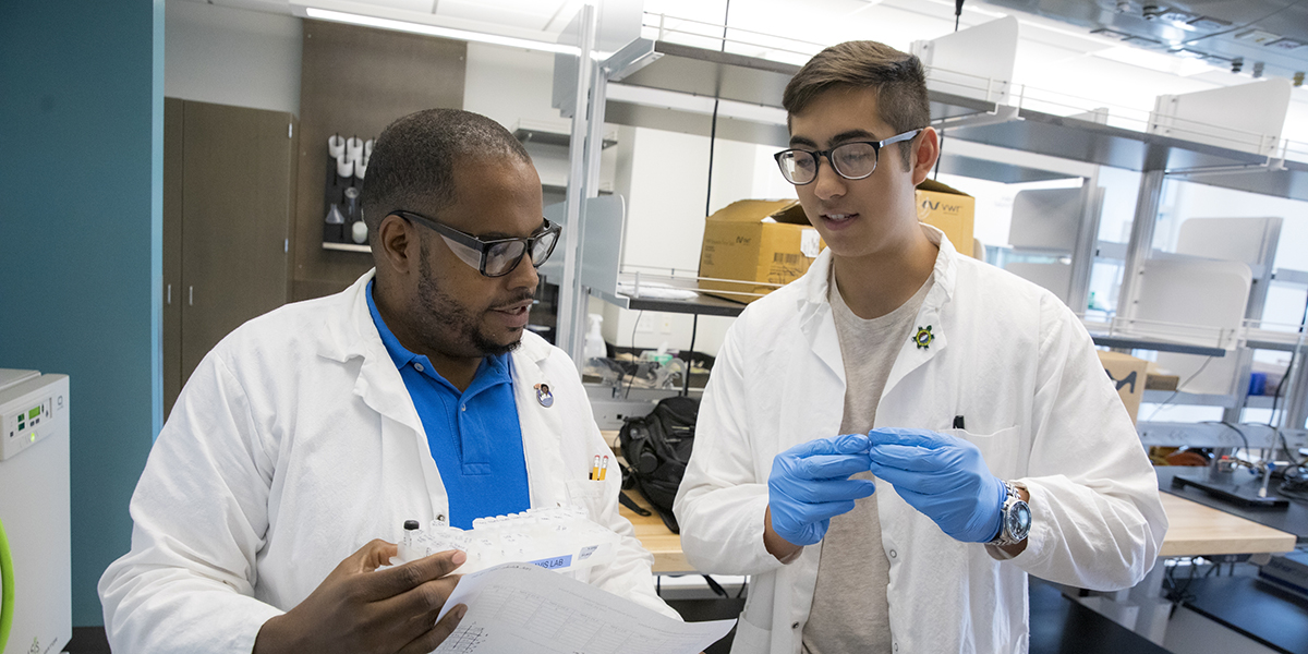 Tony Davis, assistant professor of pharmaceutical sciences, speaks with his undergraduate student, Kaiyu Tio.