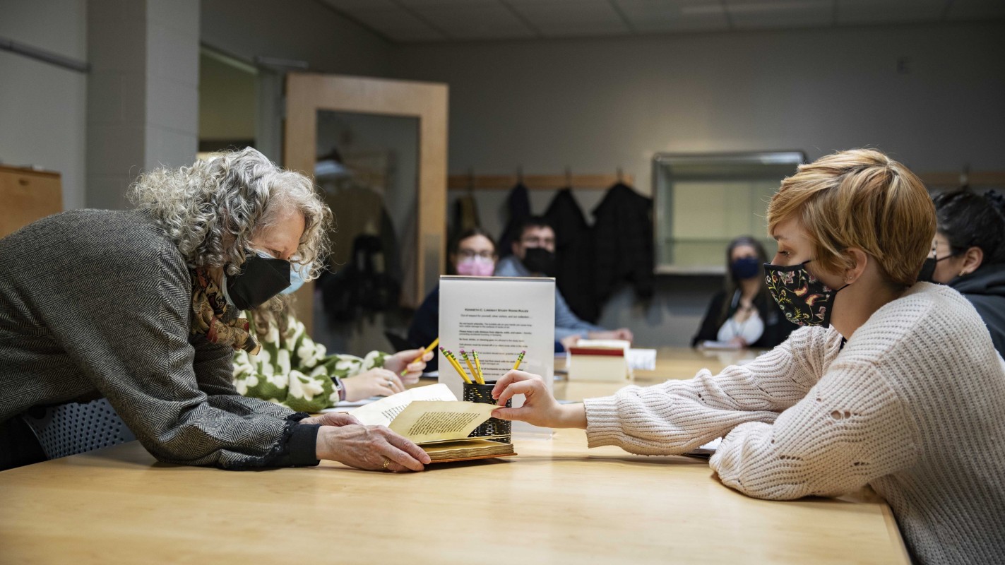 Distinguished Professor of English Marilynn Desmond invites a student in her Women and Society in Medieval Literature class to touch a parchment manuscript. Nine texts from the 13th to 16th centuries were on exhibit this spring in the Binghamton University Art Museum.