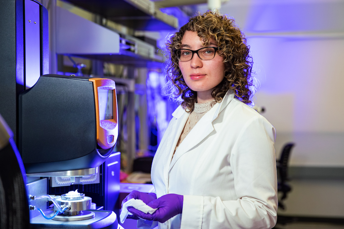 Undergraduate Clara Rodriguez stands beside a rheometer in the Analytical and Diagnostics Laboratory at the Innovative Technologies Complex. Rodriguez studies biomedical engineering under Associate Professor Guy German.