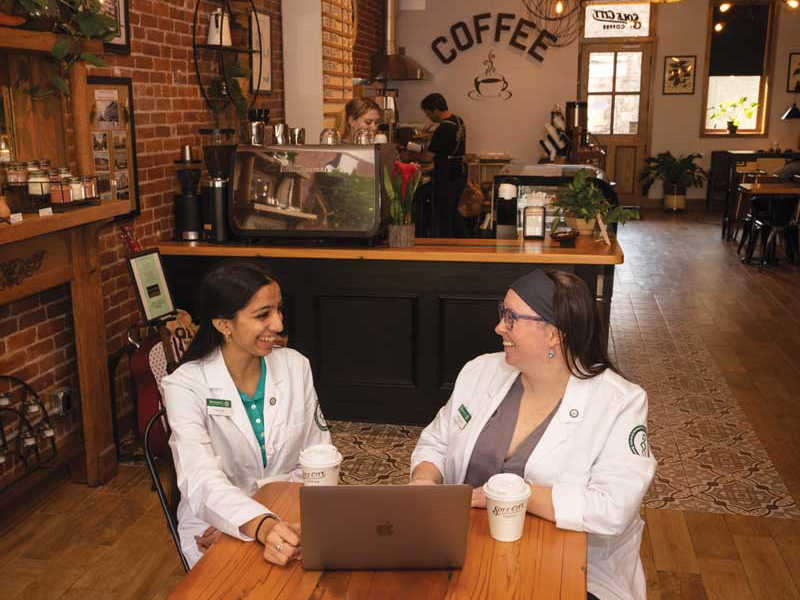 School of Pharmacy and Pharmaceutical Sciences students Heeral Naik and Corey Graziade, both in their first year of the PharmD program, enjoy a cup of coffee at Sole City Coffee in downtown Johnson City.