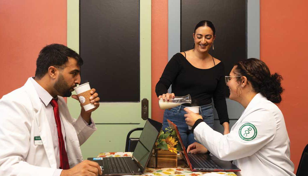 The Grapevine Café owner Rita Moelder serves School of Pharmacy and Pharmaceutical Sciences second-year PharmD student Arshad Ali, left, and fourth-year PharmD student Erin Wong as they catch up on coursework.