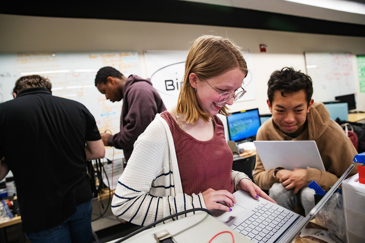 Becca Carpenter, left, and Chris Yang work together on a computer among other Binghamton University Rover Team members in the Fabrication Lab of the Engineering Building.