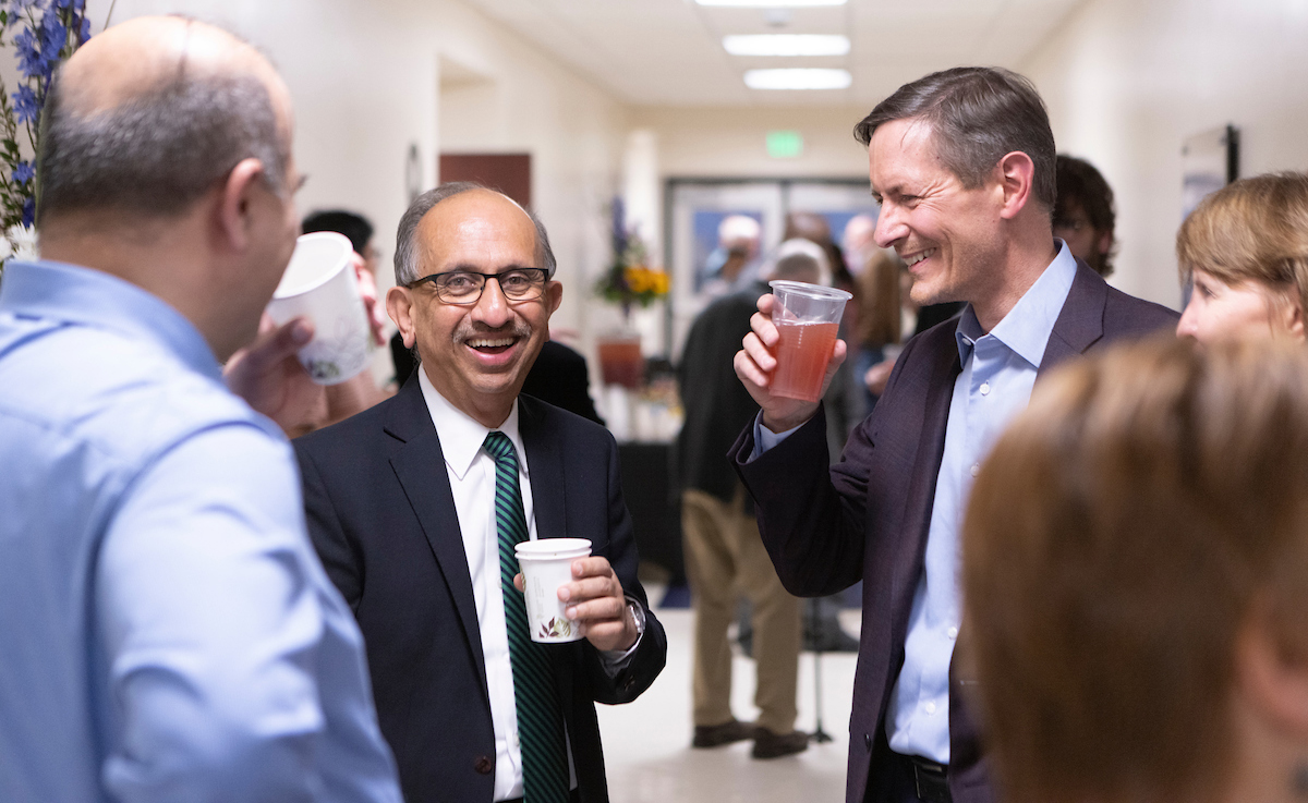 Watson College Dean and Distinguished Professor Krishnaswami “Hari” Srihari has a laugh with guests after the dedication of a boardroom in his honor at the Engineering Building.