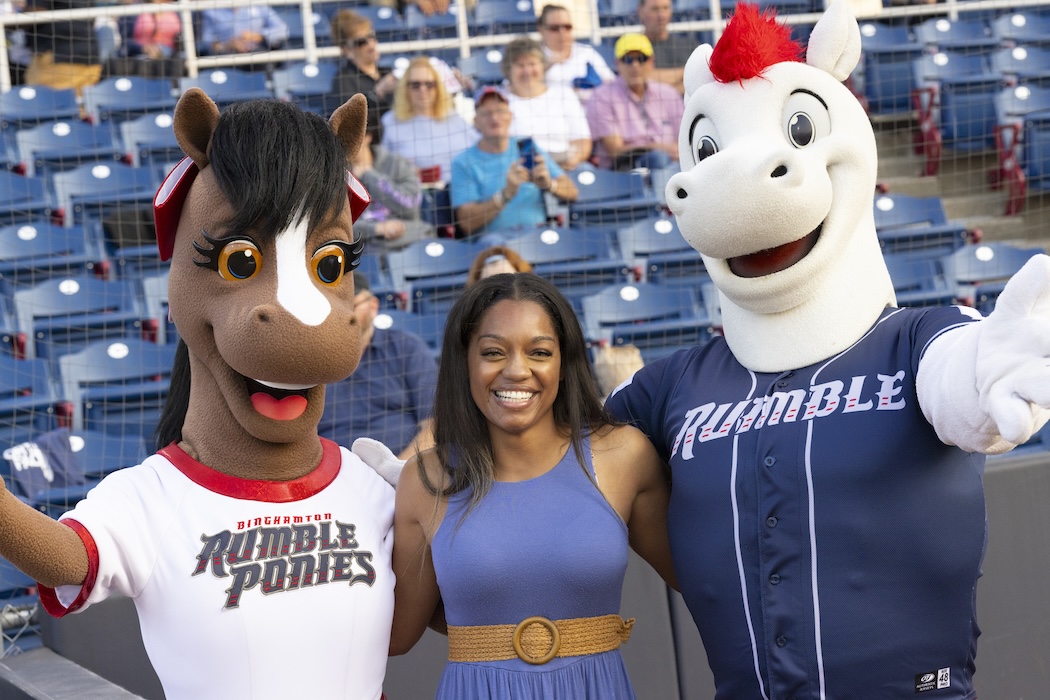 Ashanté Concepcion celebrates her performance with the mascots of the Rumble Ponies.