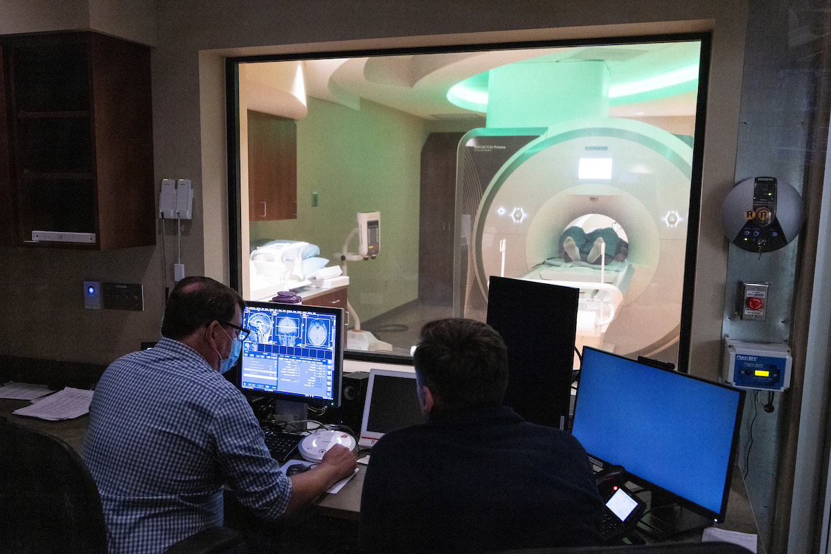 J. David Jentsch, Distinguished Professor and Chair of Psychology, left, demonstrates the use of the new magnetic resonance imaging (MRI) scanner at the United Health Services (UHS) building off campus, October 9, 2023.