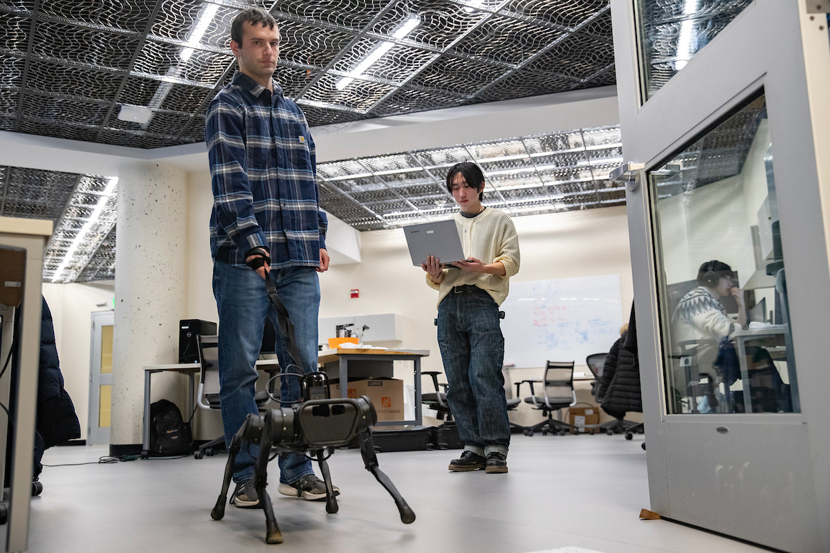 Among the projects at Associate Professor Shiqi Zhang’s lab is programming a robot guide dog to assist the visually impaired. Here, PhD student David DeFazio and undergraduate Eisuke Hirota test a robot responding to tugs on its leash.