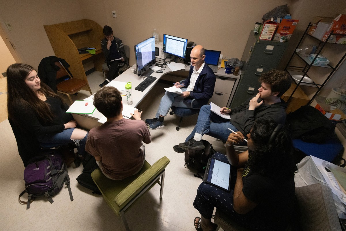 Associate Professor of Mathematics and Statistics Alexander Borisov hosts a problem-solving session on the evening of March 26, 2024, at his Whitney Hall office, where students participating in the William Lowell Putnam Mathematical Competition practice their skills. Borisov, center, leads a disccusion with students, from left, Blanca Parker, Nikita Safronov, Sasha Aksenchuk, Levi Axelrod and Alif Miah.