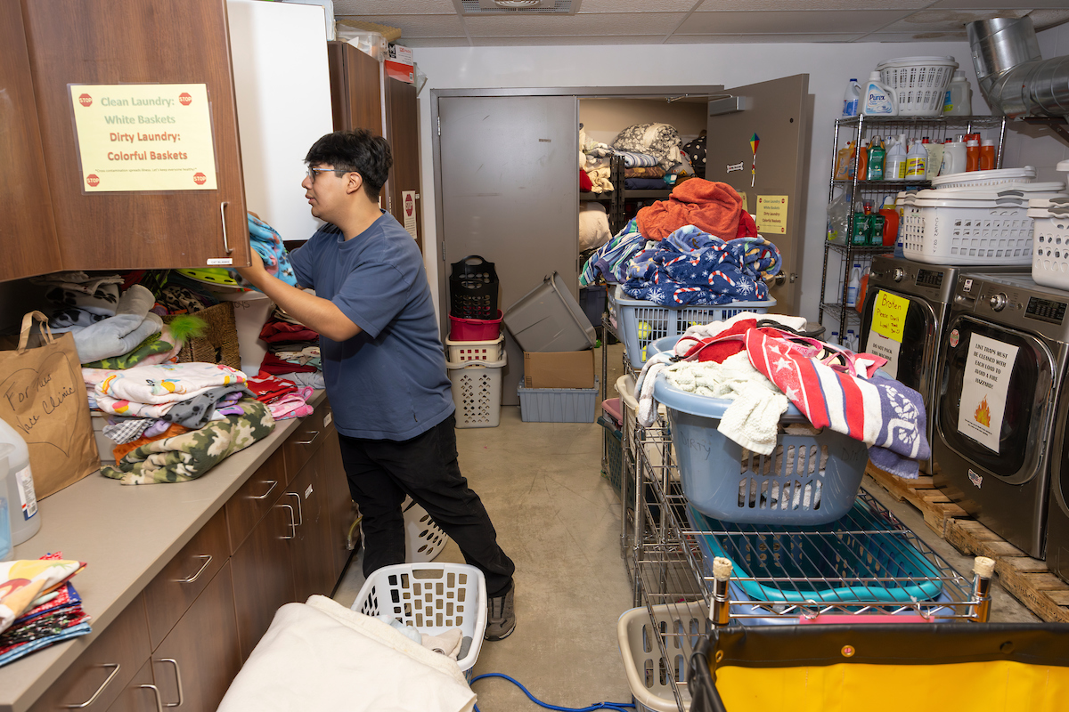 Bryan Perez ’25 grabs towels in the supply room while volunteering at the Broome County Humane Society in Binghamton.