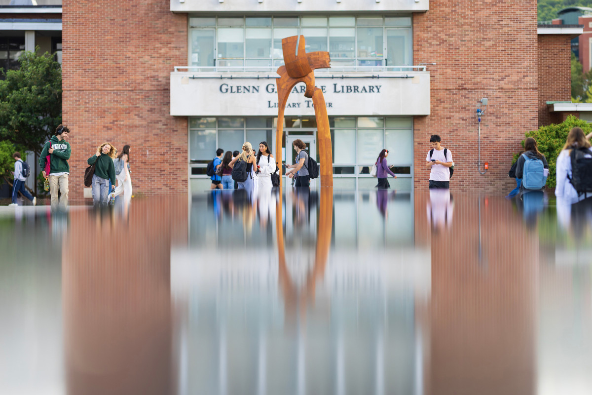Students walk by the fountain at Harpur Quad by the Glenn G. Bartle Library Tower.