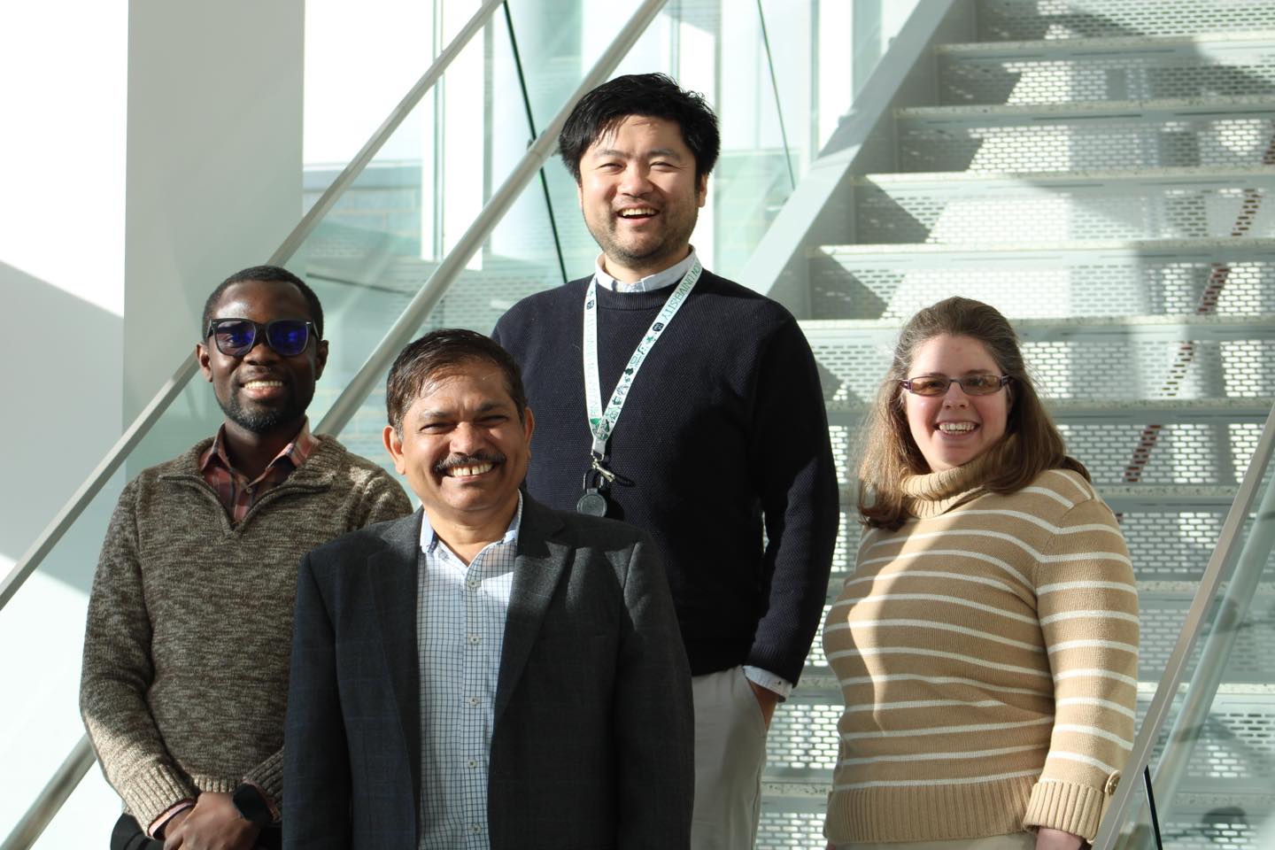 New SOPPS faculty members Associate Professor John Fetse (left), Assistant Professor Yuanjun “Steve” Shen (back center) and Clinical Assistant Professor Kelly Bach (right) pose with Dean and SUNY Distinguished Professor Kanneboyina Nagaraju (front center) on the stairs of the atrium inside the School of Pharmacy and Pharmaceutical Sciences.