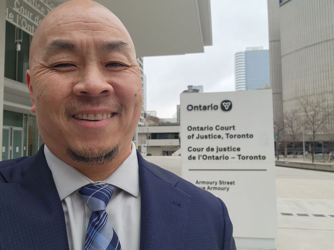 Sin Senh ’97, MA ’05, president and CEO of the environmental consulting firm Roux, stands outside of a courthouse where he'll be giving expert testimony in a case.