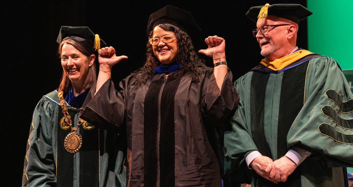 A graduate celebrates with Binghamton University President Anne D'Alleva and Provost Donald Hall during the doctoral hooding ceremony Thursday.
