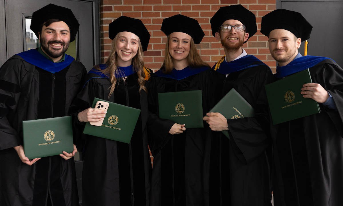 Newly minted PhDs celebrate after Thursday's doctoral hooding ceremony.