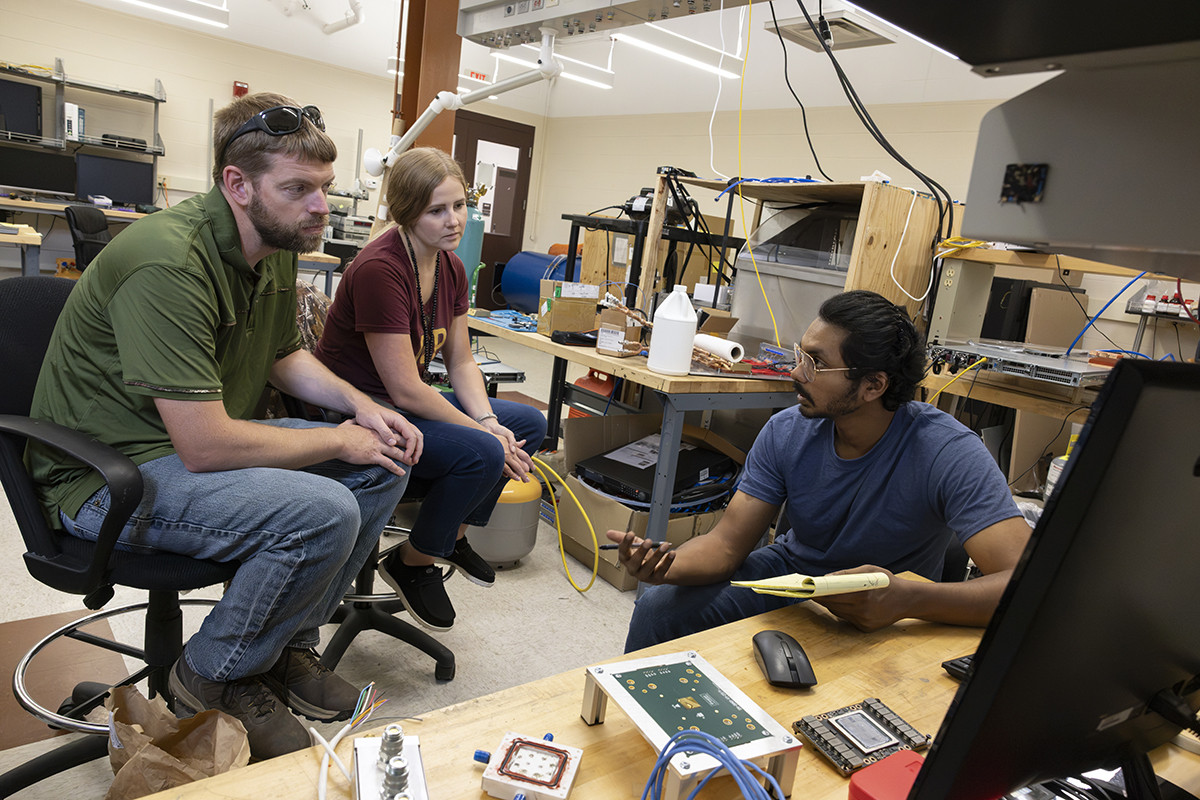 Mechanical engineering PhD student Sidharth Rajeev, right, teaches Jason Dewey of Windsor Central Middle School and Morgan Hill, an eighth-grade science teacher at Whitney Point Central School District, about data center cooling in Distinguished Professor Bahgat Sammakia's lab at Binghamton University's Innovative Technologies Complex. Dewey and Hill were part of the Research Experiences for Teachers program.