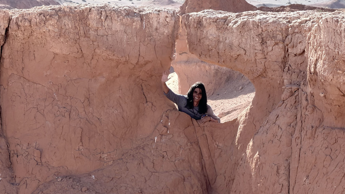 Sustainable Communities graduate student Andrew Cohen strikes a pose at cliffs in the Gobi Desert.