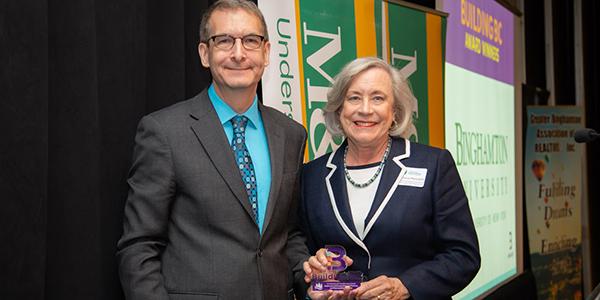 Founding Dean Gloria Meredith accepts the 2019 BC Transformative Award from James McDuffee, vice president and COO at Delta Engineers, Architects and Land Surveyors, at the Greater Binghamton Chamber of Commerce awards ceremony.
