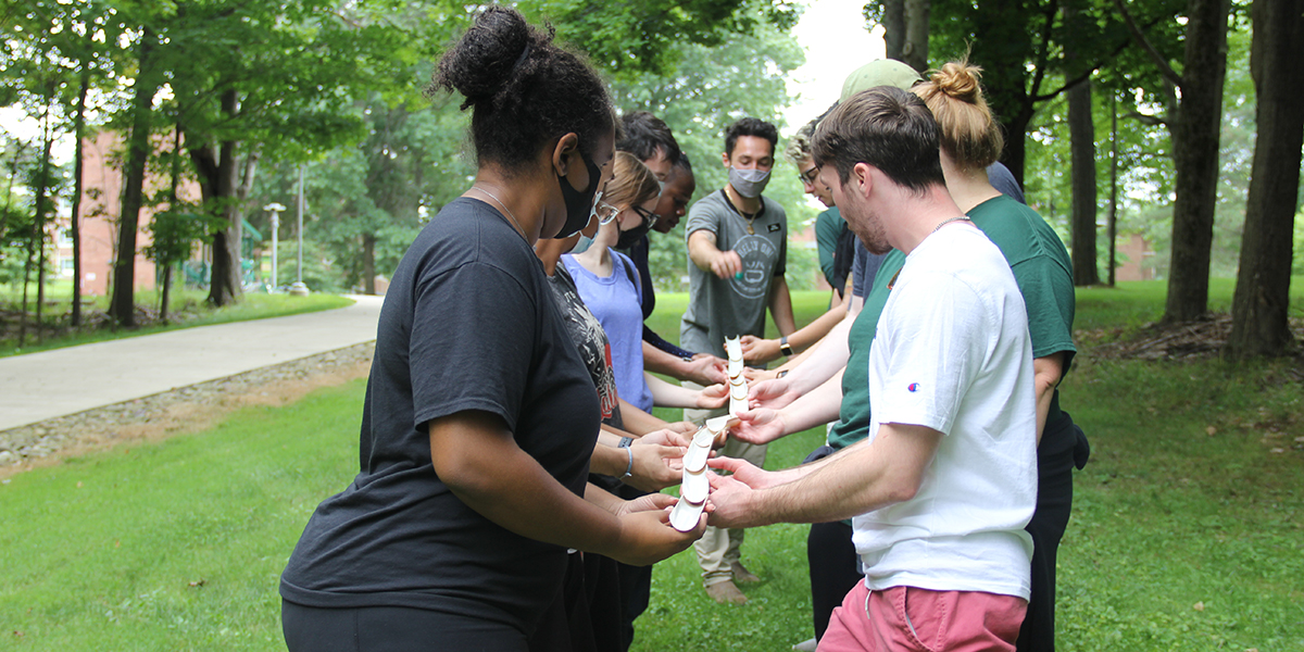 Participants in the Challenge Course program try an icebreaking activity, working as a team to move a marble from one point to another using cut tubes.