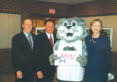 Athletics Director Joel Thirer, left, America East Commissioner Chris Monasch, and President Lois DeFleur celebrated with Baxter the Bearcat after Binghamton University joined the America East Conference in April 2001.