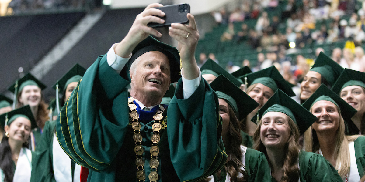 Binghamton University President Harvey Stenger takes a selfie with Decker College of Nursing and Health Sciences graduating students at the Commencement ceremony May 9.