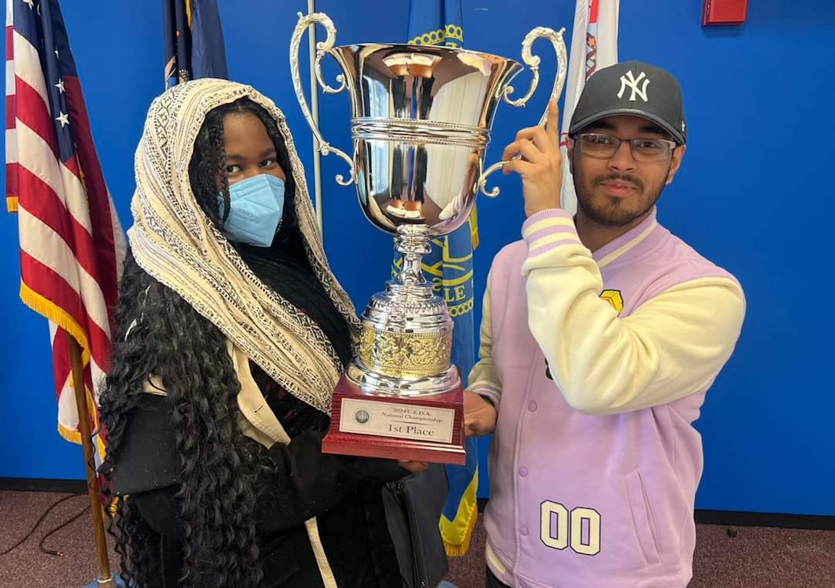 Eli Turner-Louis and Akif Choudhury stand with their Cross-Examination Debate Association (CEDA) trophy. The pair led Binghamton University to a national victory over Wake Forest University at the competition.