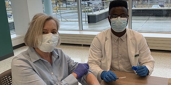 School of Pharmacy and Pharmaceutical Sciences Dean Gloria Meredith receives her annual flu shot from P4 student Sulemana Mohammed.
