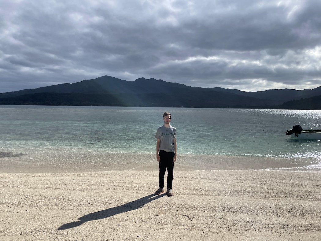 Student Matthew Christian stands on a beach in Vanuatu while taking part in the Health Transition project.