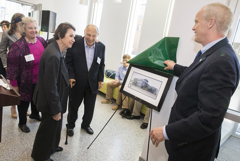 Binghamton University President Harvey Stenger presents a framed rendering of the Koffman Southern Tier Incubator to the Koffman family at a Binghamton University Forum event Tuesday at the new incubator. From left are Betsy Koffman and her parents, Ruthanne and Bud Koffman.