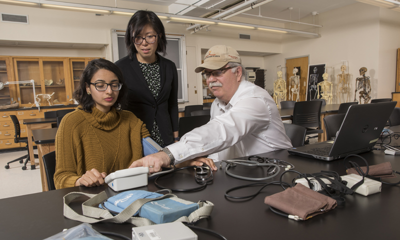 Gary James, graduate director of the biomedical anthropology program, works with students Zara Shah, left, and Jane Pechera in Science 1.