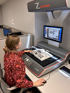 Digital Initiatives Assistant Caitlin Holton uses an overhead scanner to digitize a book for the University Libraries’ collection.