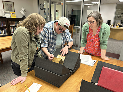 CEMERS Director Elizabeth Casteen guides graduate students on key elements of the manuscript. Students use materials like the breviary to gain practical field experience.