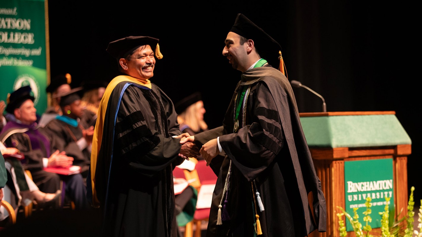 Dean and SUNY Distinguished Professor Kanneboyina Nagaraju congratulates Doctor of Pharmacy graduate Nicholas Lukan.