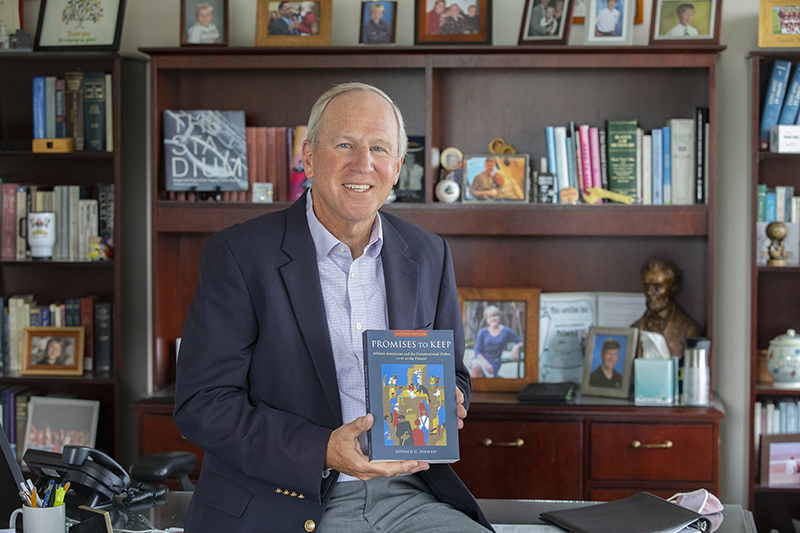 Donald Nieman, executive vice president for academic affairs and provost at Binghamton University, holds his recently released book, 