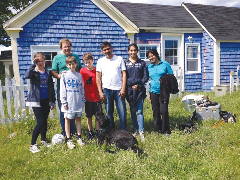 Outside of the lab, the scientists, shown here with family members, work on rehabbing 30 apple trees from the mid-1800s in a Nova Scotia orchard.