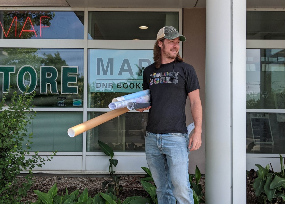 Geological sciences graduate student Kristian Olson carries maps during fieldwork.