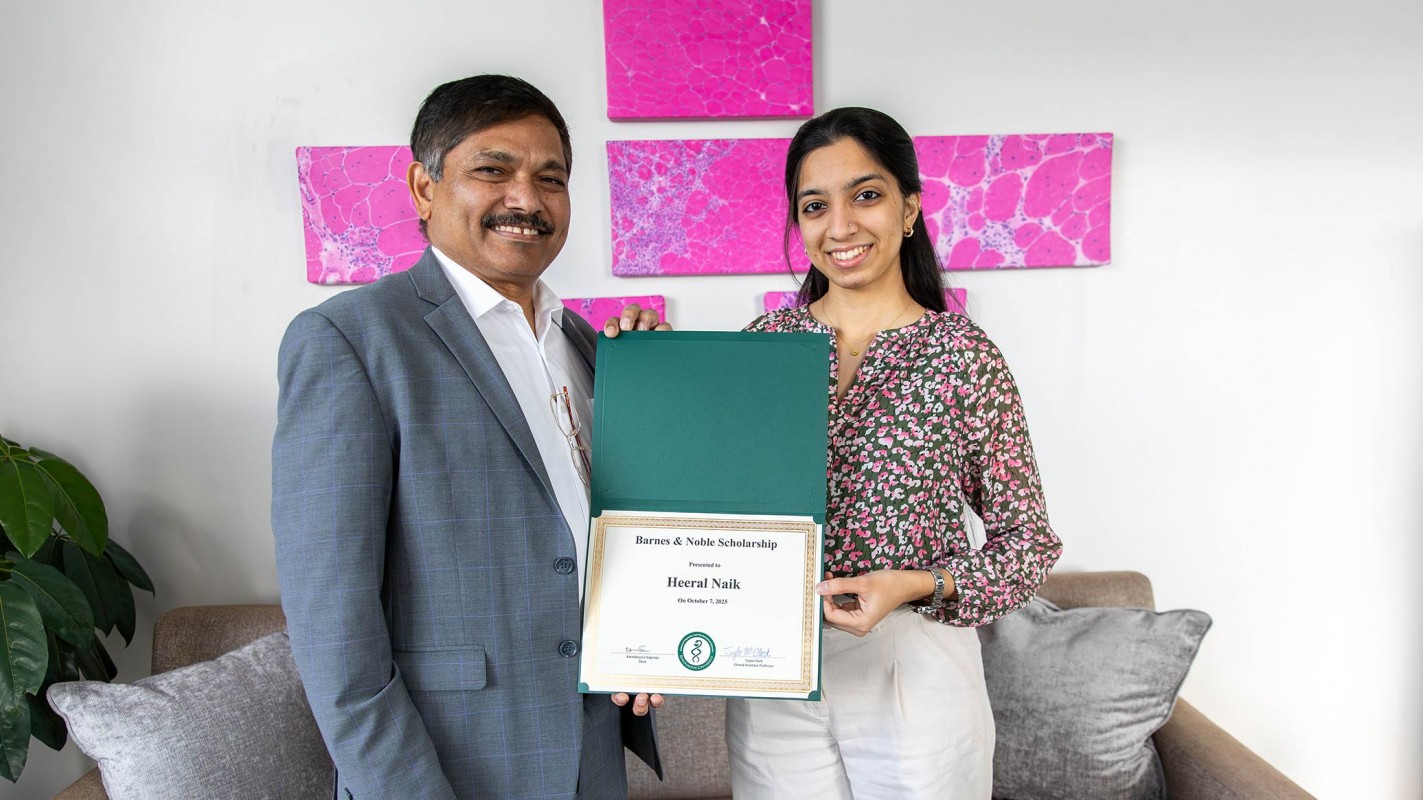 Dean and SUNY Distinguished Professor Kanneboyina Nagaraju presenting a Barnes & Noble Scholarship certificate to P4 student Heeral Naik.