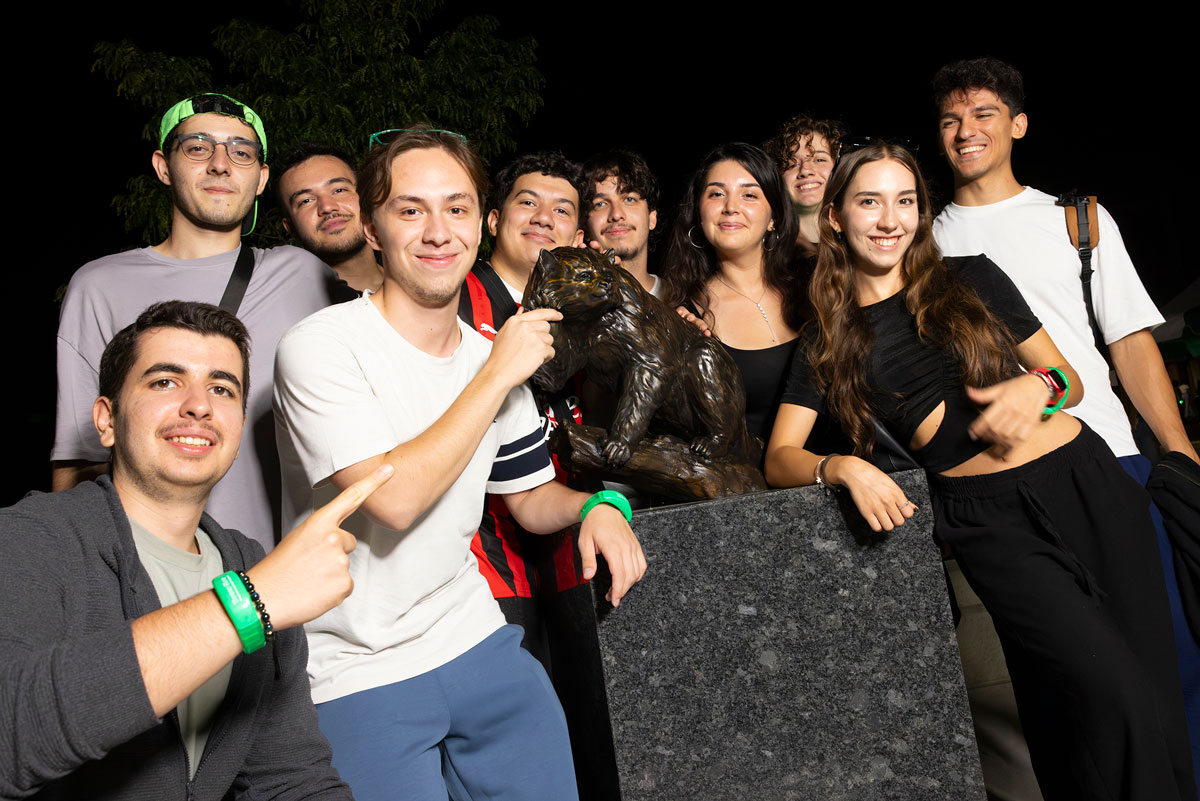 Students pose with Bing the binturong statue during Tower Glow.