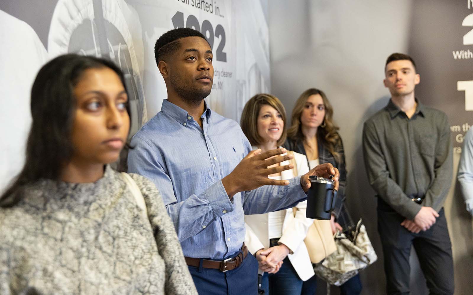 SOM Transformational Leaders Program Coordinator Jerah Reeves, center, poses a question during an April 2022 visit to Cleaners Supply in Conklin, N.Y.
