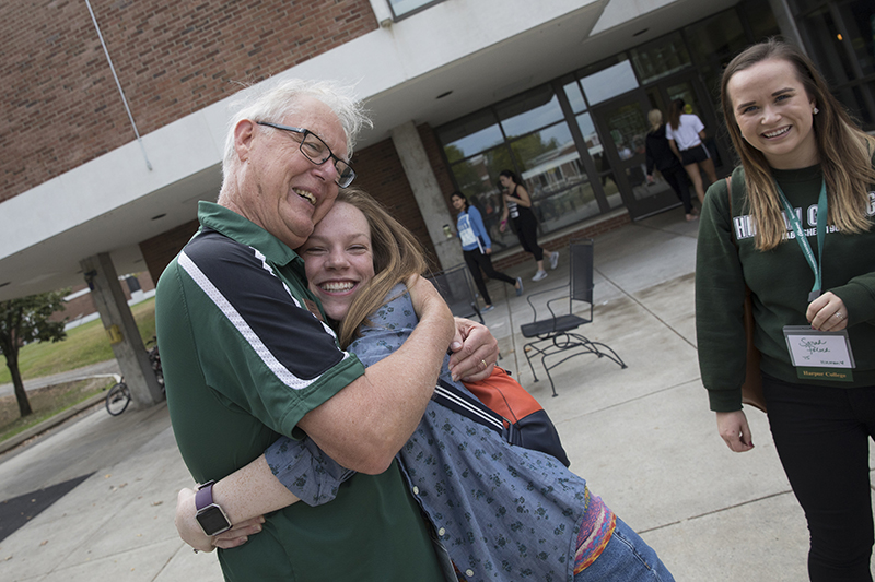 Al Vos greets Deedi Boland Brown '14 during the 2017 Homecoming.