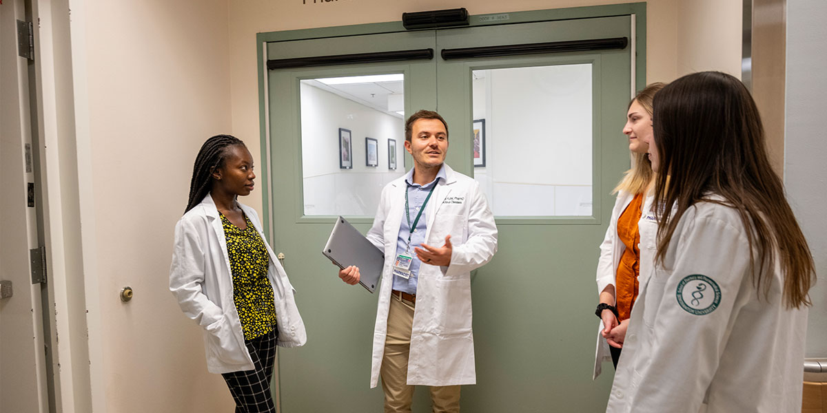 Clinical Associate Professor Wesley Kufel working with Binghamton University School of Pharmacy students.