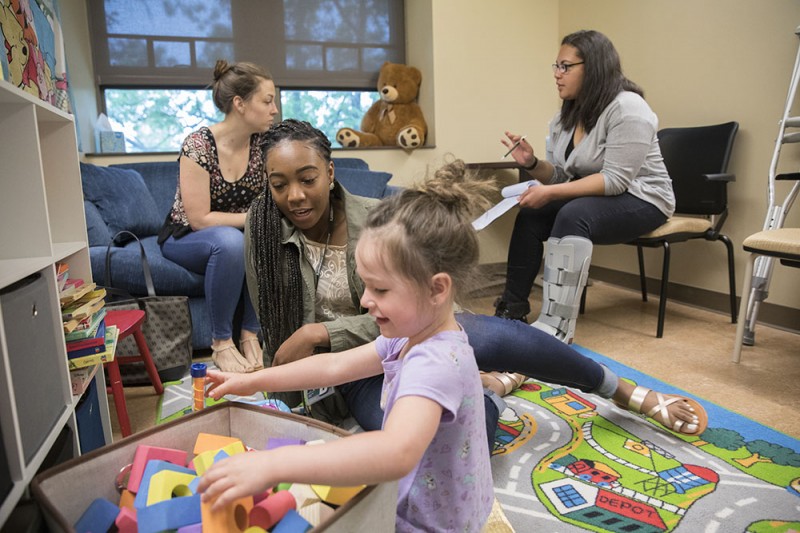 Taylor Hitchcock (right) in summer 2017 working as part of Bridges to the Baccalaureate program with transfer student Jazlynn Gray with children and their mothers in Peter Gerhardstein's lab.