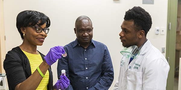 Mark Tettey, a Bridges to the Baccalaureate Program scholar from Westchester Community College (right), works with chemistry professor Omowunmi Sadik and postdoc Francis Osonga at the Smart Energy Building.