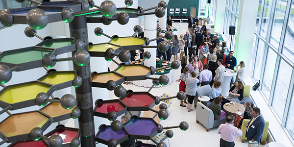 People gather in the atrium of the School of Pharmacy and Pharmaceutical Sciences following tours of the building given during a VIP reception Aug. 13.