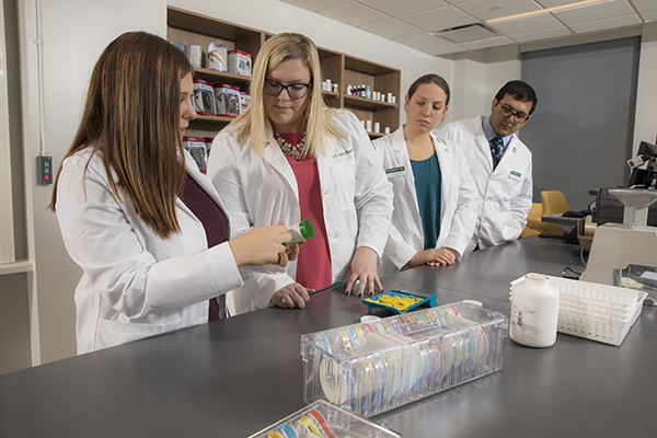 Students work with Clinical Assistant Professor of Pharmacy Practice Emily Leppien, second from left, in the School of Pharmacy and Pharmaceutical Sciences community pharmacy.
