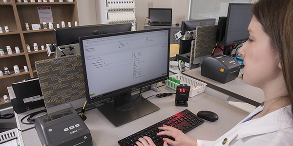 Sarah Lynch, assistant clinical professor of pharmacy practice, uses a software system she is developing with colleagues that will improve the student educational experience for dispensing prescriptions.