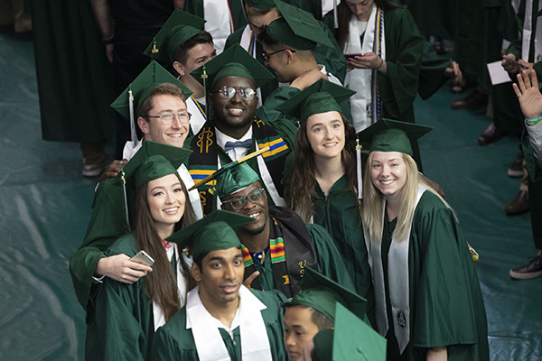 Students graduating from the Thomas J. Watson School of Engineering and Applied Science pose for the photographer while queuing in line to cross the stage for their degrees.