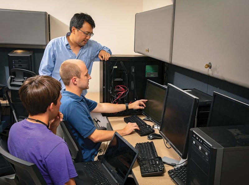 Professor Yu “David” Liu discusses ideas in his lab with students Jeffery Eymer, center, and David Fletcher.