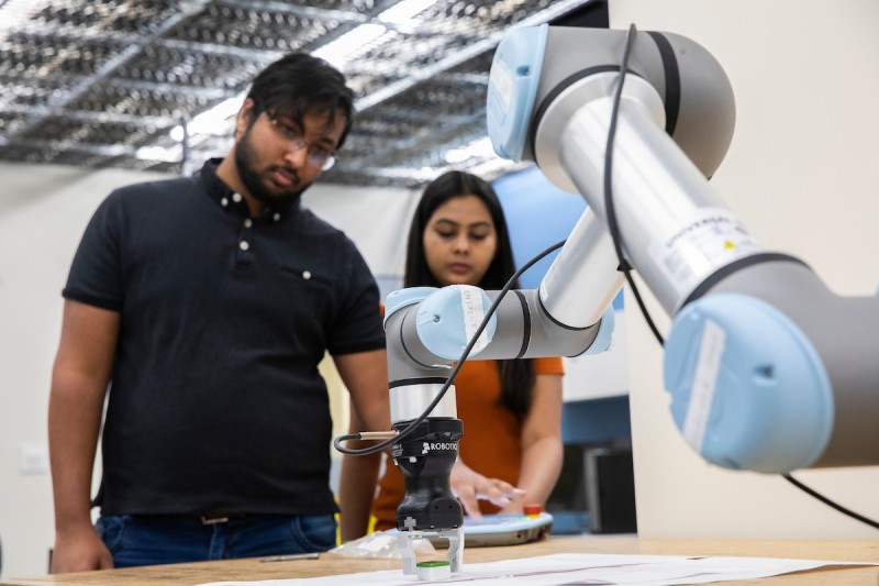 PhD students Kishan Chandan, left, and Vidisha Kudalkar work in Assistant Professor Shiqi Zhang’s Autonomous Intelligent Robotics Lab in the Engineering Building at Watson College.
