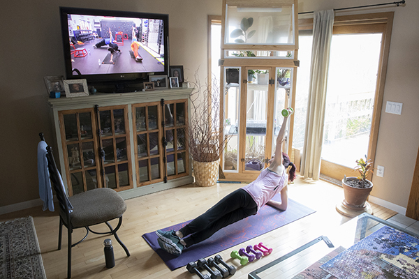 Rhonda Branca, director of Lyceum, works out at home to a virtual exercise class offered by a local gym during the New York state COVID-19 pause.