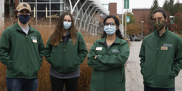 Brian Giarraputo, Vanessa Crowley, Haleema Qamar and Leonard Lederman are part of the Campus COVID Response Team (CCRT) that monitors public spaces on campus for proper use of face masks and social distancing, and rewards some students for compliance. The team, pictured here outside the University Union Oct. 28, will break into pairs to travel the campus.